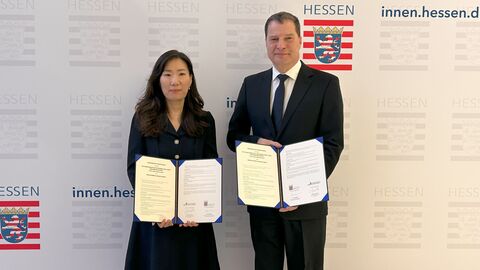 Frau Soon Joung Byun (KISA) und Ralf Stettner (CISO Hessen) präsentieren die Kooperationsvereinbarung.